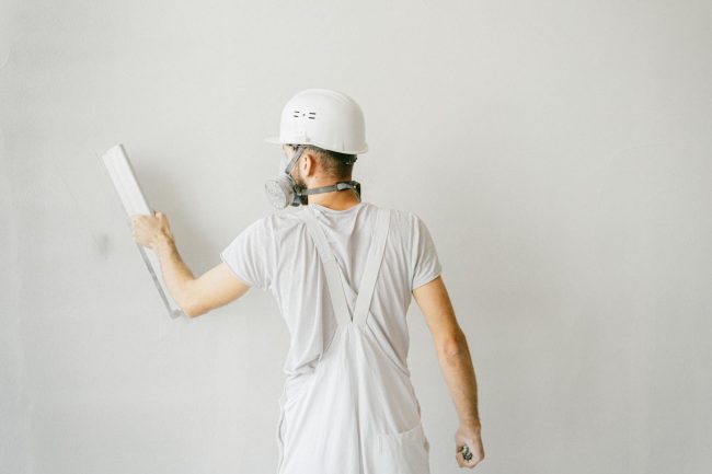Photo by Antoni Shkraba A Construction Worker Working on the Wall of a House