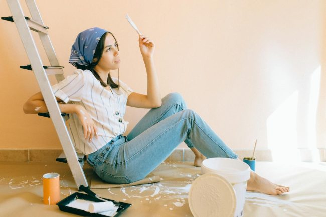 Photo by Nataliya Vaitkevich Woman Sitting on the Floor Holding a White Paintbrush