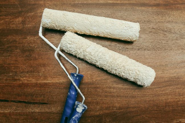 Photo by Polina Tankilevitch Two paint rollers over a wooden surface, perfect for home renovation concepts.
